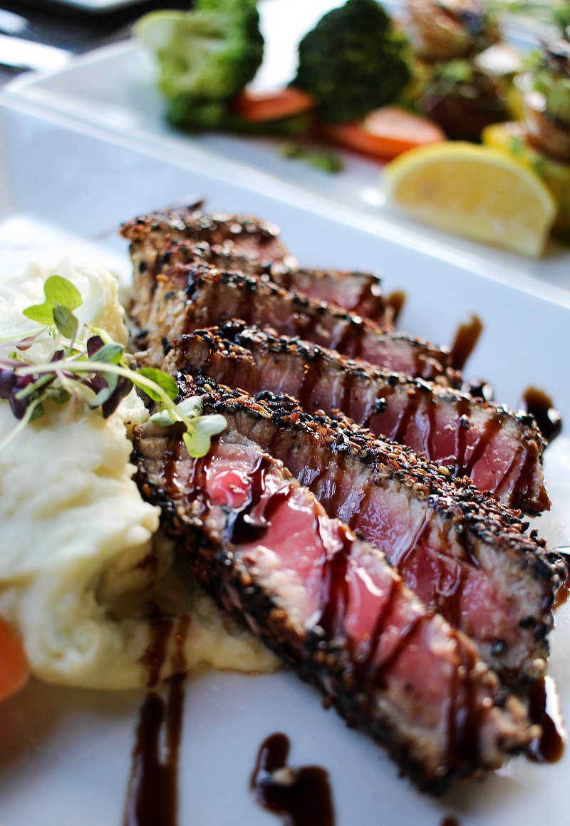 beef steak sliced with sauce drizzled on top of it